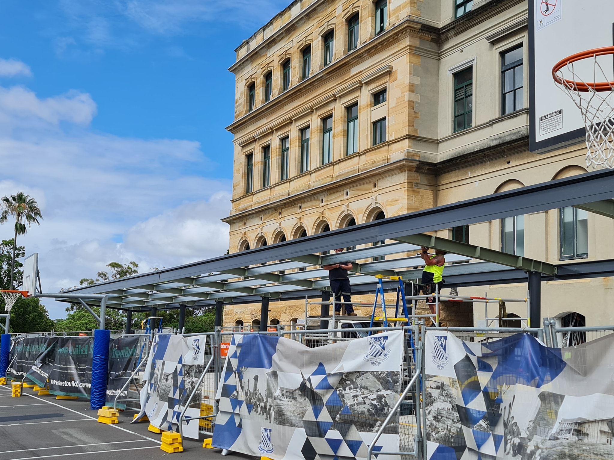 Fabricated steel cover structure over an outdoor basketball court